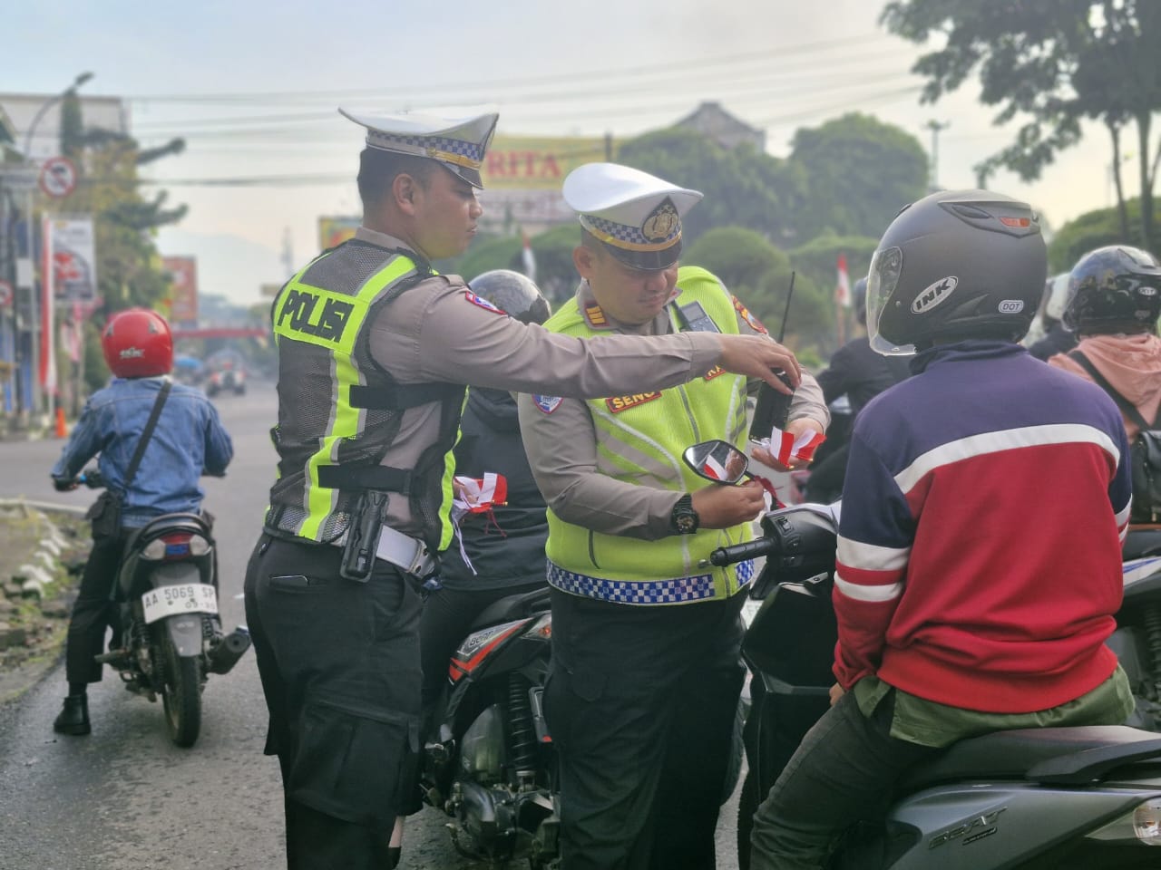 Satlantas Polres Wonosobo bagi-bagi bendera merah putih kepada pengguna jalan sebagai upaya menyambut HUT ke-80 Republik Indonesia. (Foto: Bagus Kiswanto/Proliman News).